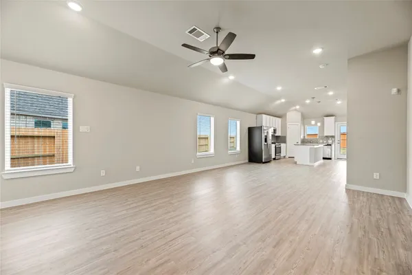 a view of an empty room with a window and wooden floor