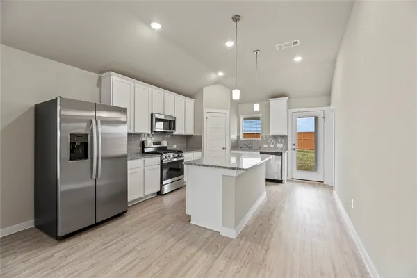 a kitchen with cabinets and stainless steel appliances