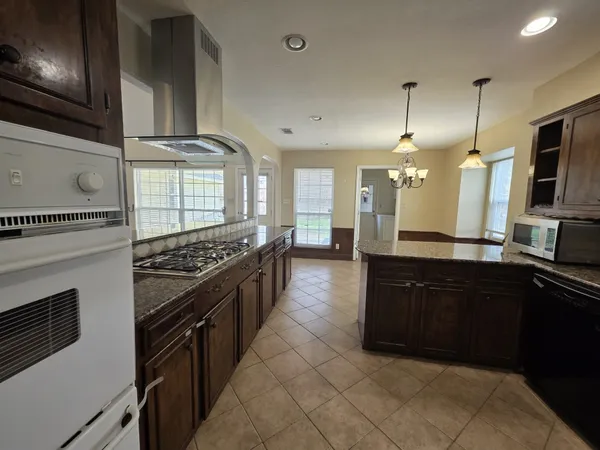 a large kitchen with a stove and a sink