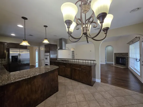 a large kitchen with granite countertop a sink a counter top space a stove and cabinets