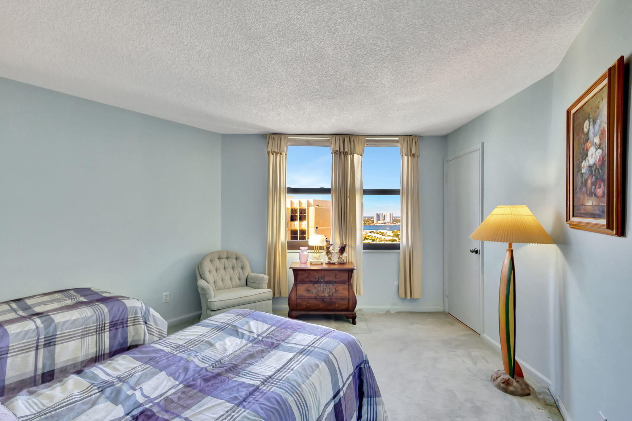 2800 North Ocean Drive, Unit A24B Singer Island, FL 33404 - Photo 24 of 65 a bedroom with a bed and a lamp next to a window