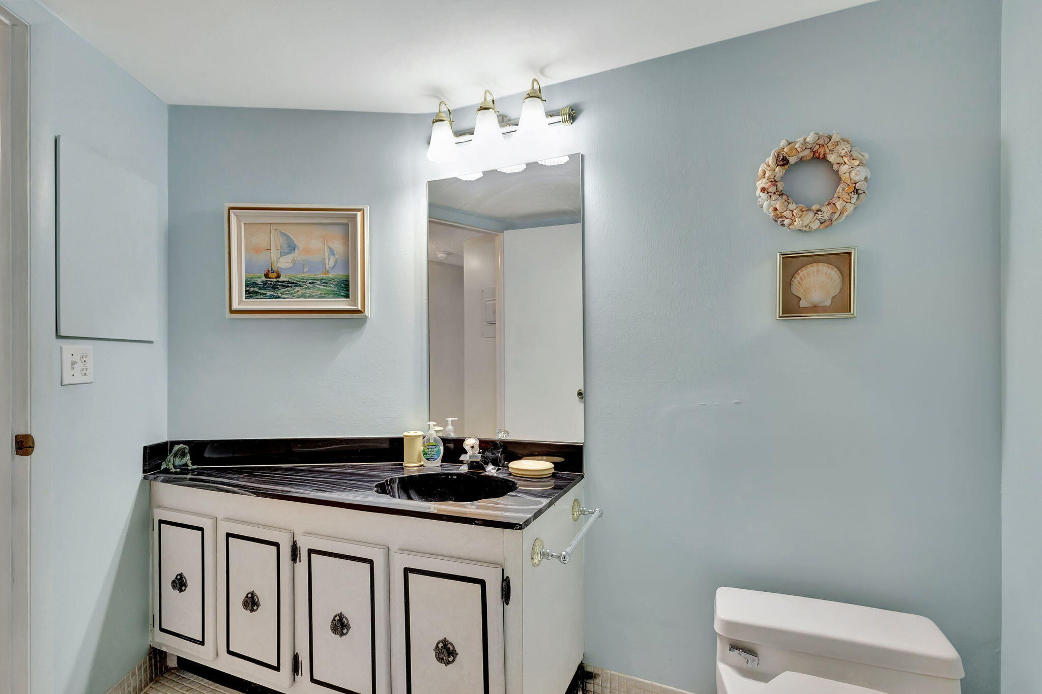2800 North Ocean Drive, Unit A24B Singer Island, FL 33404 - Photo 26 of 65 a bathroom with a sink a vanity and a mirror