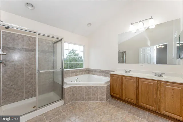 a bathroom with a bathtub a shower a sink and mirror