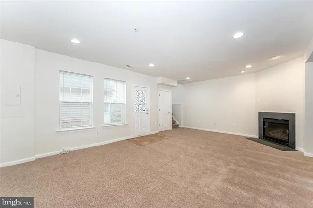 a view of an empty room with a window and fireplace