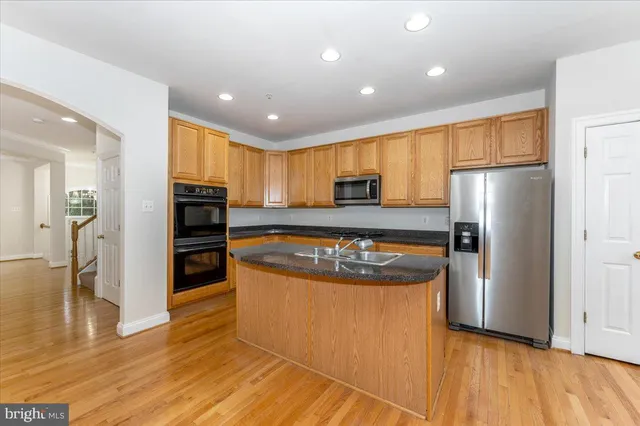 a kitchen with stainless steel appliances granite countertop a refrigerator and a stove