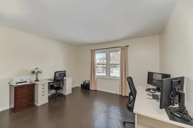 a view of a workspace with furniture and a window