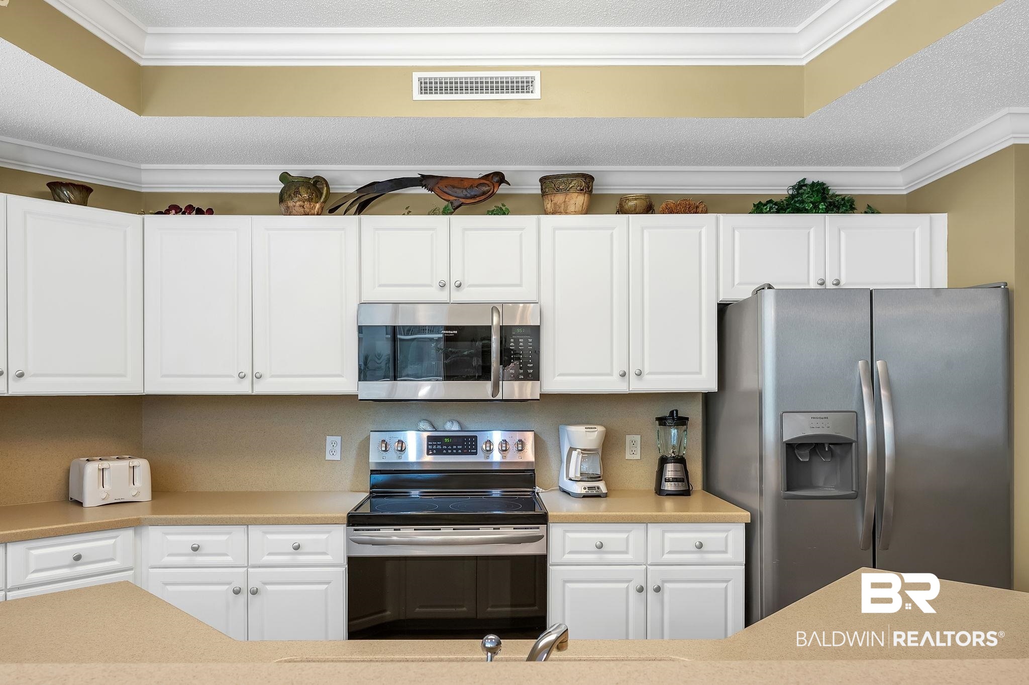 27580 Canal Road, Unit 1214 AND BOAT SLIP #62 Orange Beach, AL 36561 - Photo 18 of 67 Kitchen with crown molding, visible vents, light countertops, and stainless steel appliances