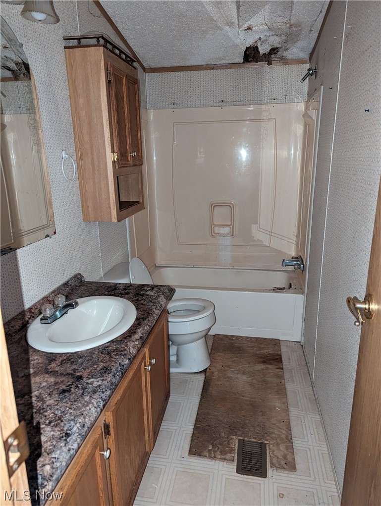 53154 Key Bellaire Road Bellaire, OH 43906 - Photo 40 of 43 Full bathroom featuring toilet, a textured ceiling, oversized vanity, bathing tub / shower combination, and tile floors