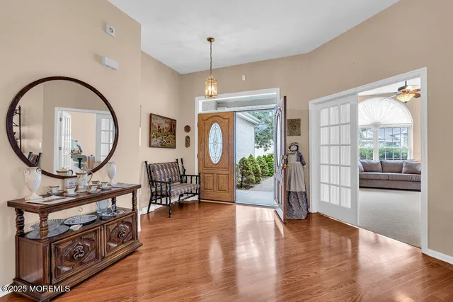 a view of a livingroom with furniture wooden floor a chandelier