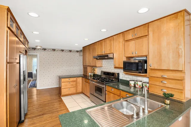 a kitchen with stainless steel appliances a stove top oven a sink and a refrigerator
