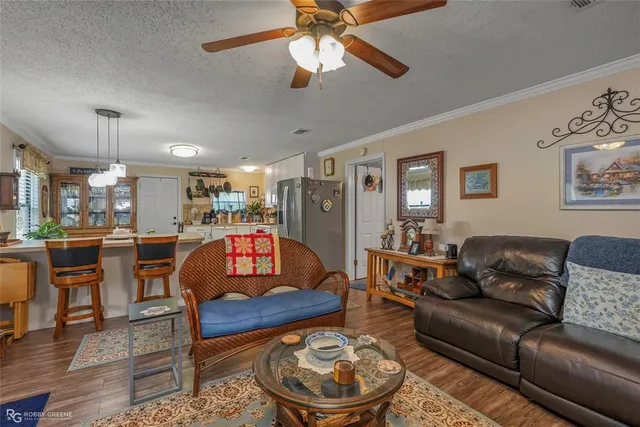 a living room with furniture a ceiling fan and a rug