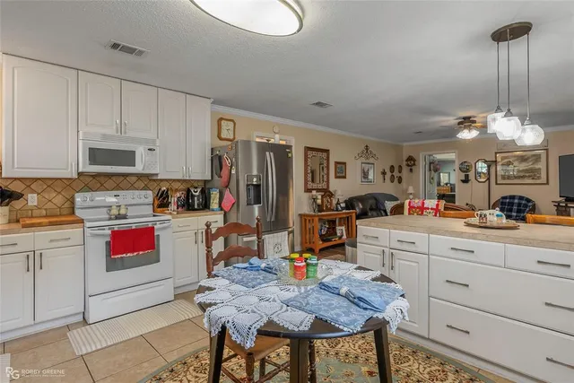 a kitchen with stainless steel appliances kitchen island granite countertop a stove a sink and a refrigerator