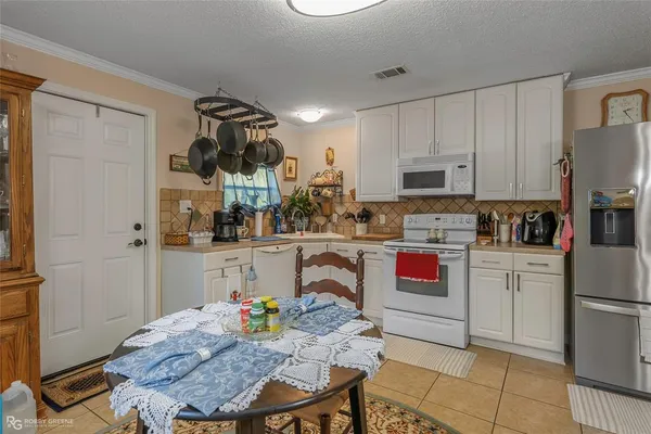 a kitchen with stainless steel appliances kitchen island granite countertop a refrigerator and microwave