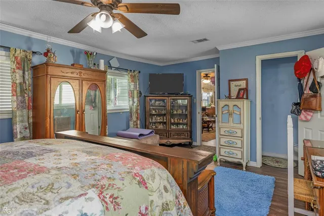 a bedroom with a bed dresser and a large window