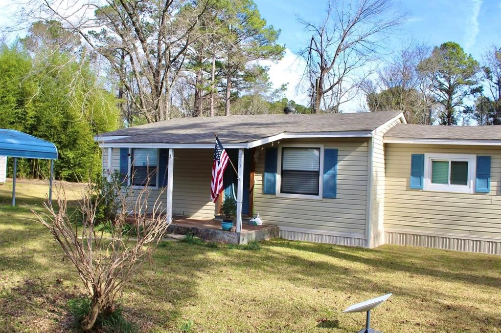 213 Bossier Street Heflin, LA 71039 - Photo 3 of 32 a view of a house with small yard plants and large tree