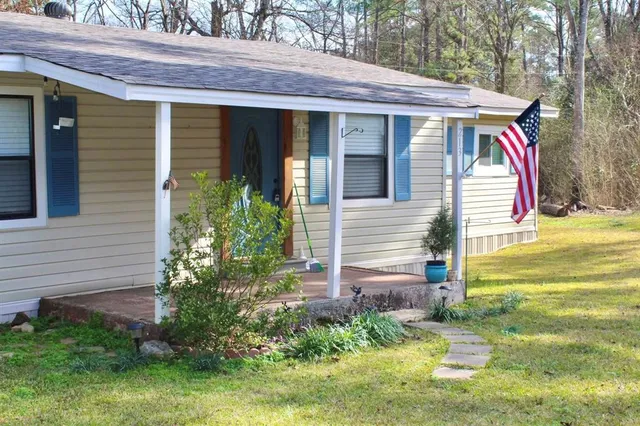 a view of a house with a yard and sitting area