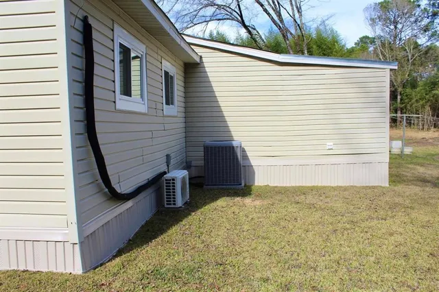 a view of a small house with backyard and deck