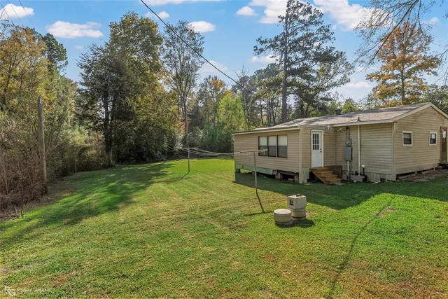 a view of a house with backyard and a tree