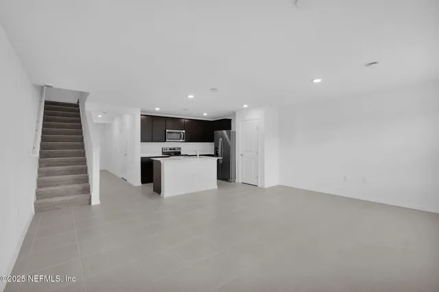 a view of an empty room with kitchen