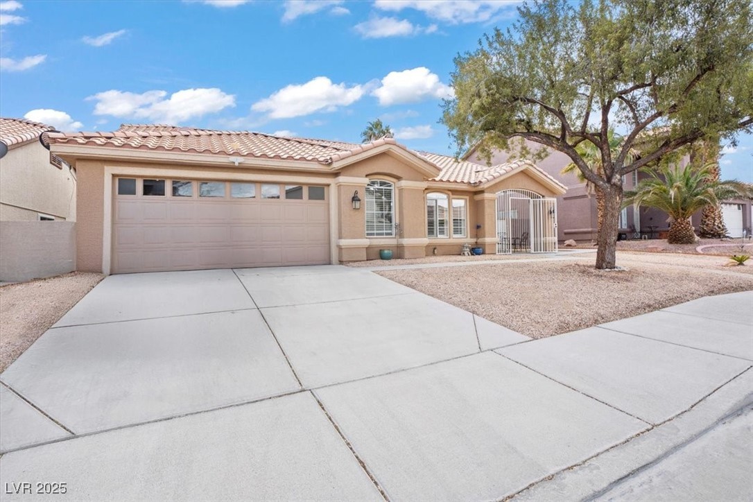 9031 West Viking Road Las Vegas, NV 89147 - Photo 2 of 33 Mediterranean / spanish-style home with a tile roof, stucco siding, concrete driveway, and a garage