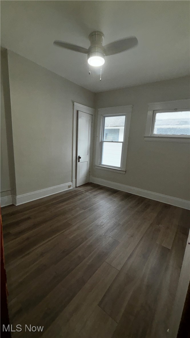 13421 Ashburton Road Cleveland, OH 44110 - Photo 20 of 28 Empty room with dark hardwood / wood-style flooring, a wealth of natural light, and ceiling fan