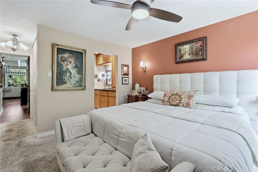7890 East Spring Street, Unit 2L Long Beach, CA 90815 - Photo 21 of 47 a bedroom with a large bed and a chandelier