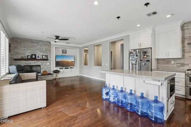 a large white kitchen with lots of counter space and chandelier