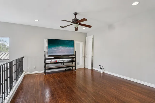 a view of a livingroom with wooden floor and a ceiling fan