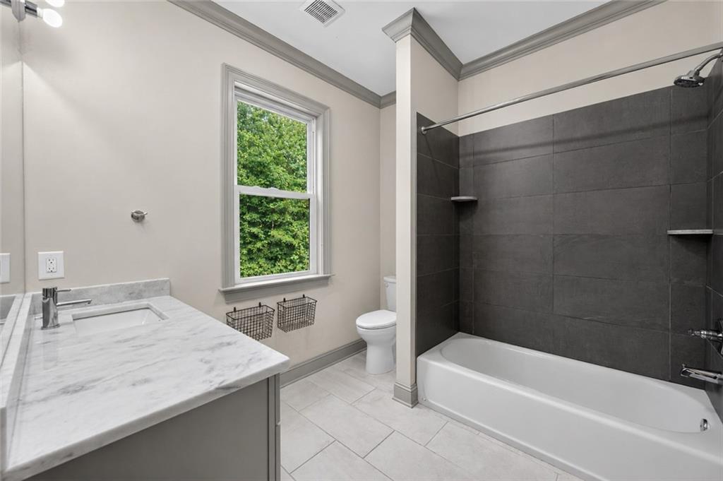 632 Geiger Road Jefferson, GA 30549 - Photo 39 of 55 a bathroom with a granite countertop bathtub a sink and a window