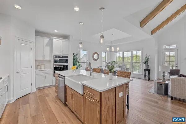 a large kitchen with kitchen island a large island a sink a stove and wooden floor