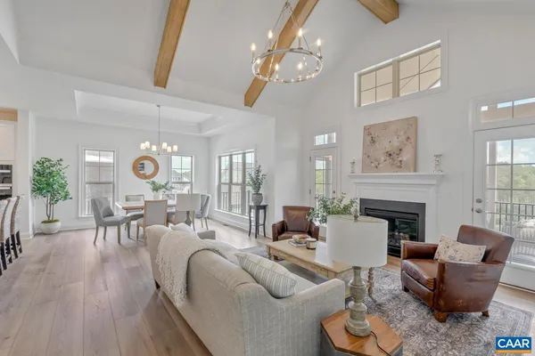 a living room with furniture a fireplace and a chandelier