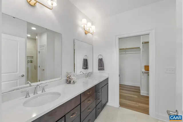 a bathroom with a double vanity sink a mirror and a shower