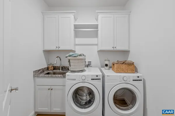 a utility room with sink dryer and washer