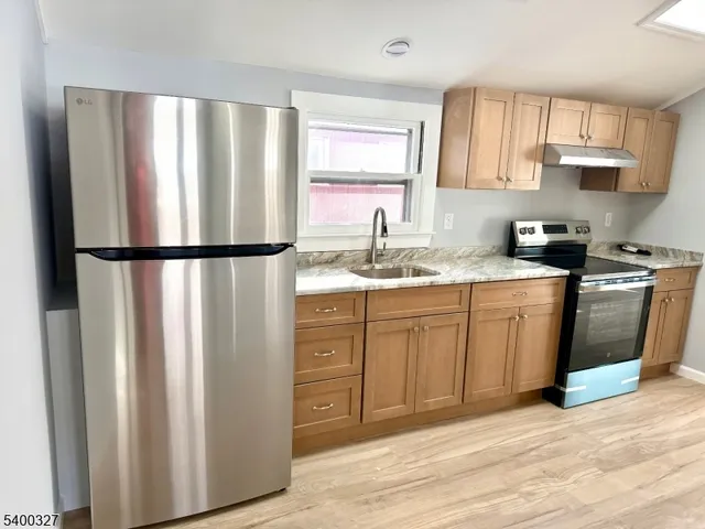 a kitchen with stainless steel appliances a refrigerator sink and cabinets