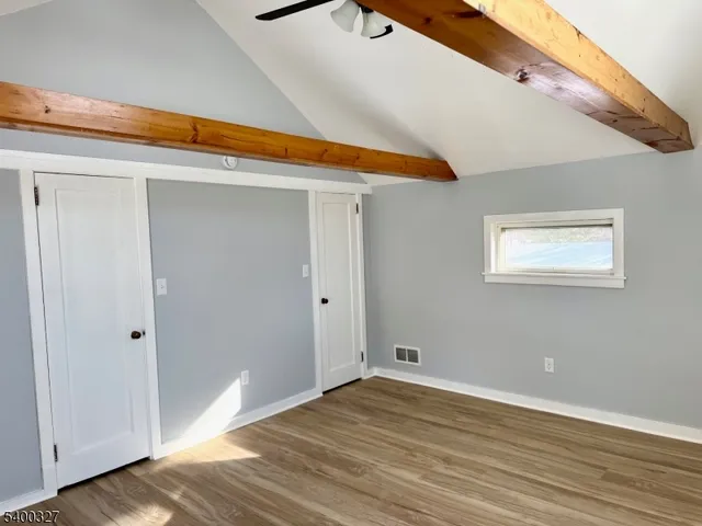 a view of a room with wooden floor and white walls