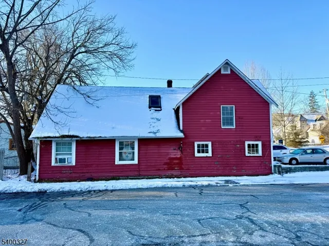 a red brick house with large windows and a large tree