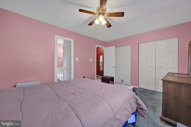 a bedroom with a bed chandelier and a window