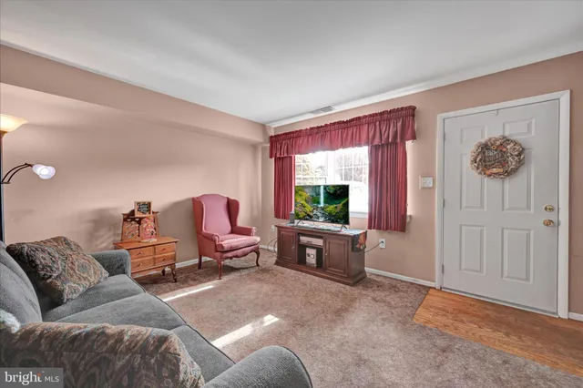a living room with furniture a window and a flat screen tv