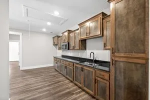 a kitchen with stainless steel appliances granite countertop a sink a stove and a wooden floors