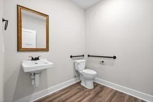 a bathroom with a sink toilet and a mirror