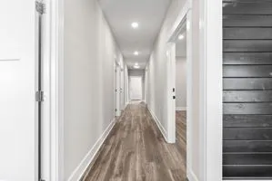 a view of a hallway with wooden floor and staircase