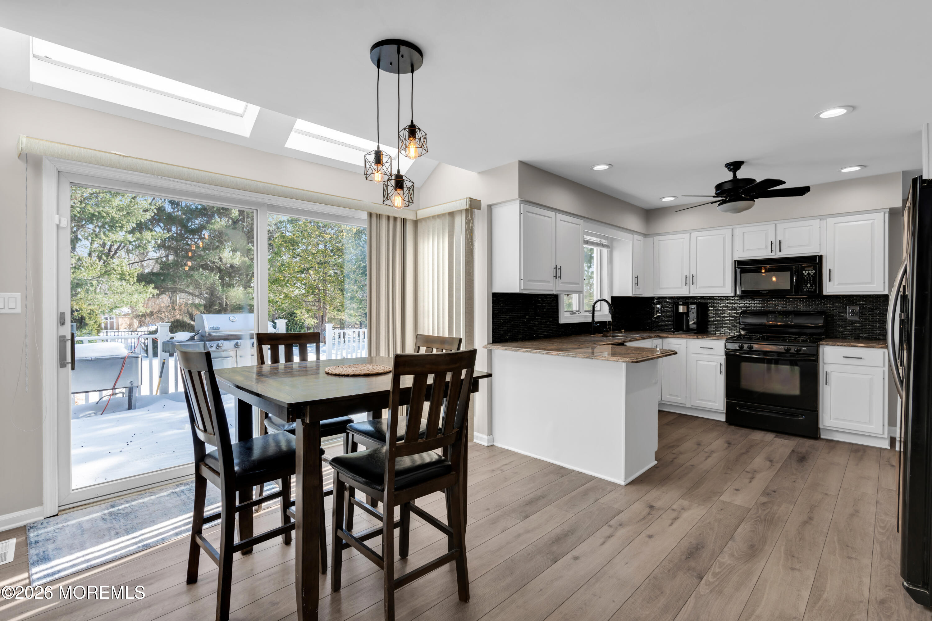 15 Lenape Trail Freehold, NJ 07728 - Photo 27 of 27 a kitchen with stainless steel appliances kitchen island granite countertop a wooden table chairs and white cabinets