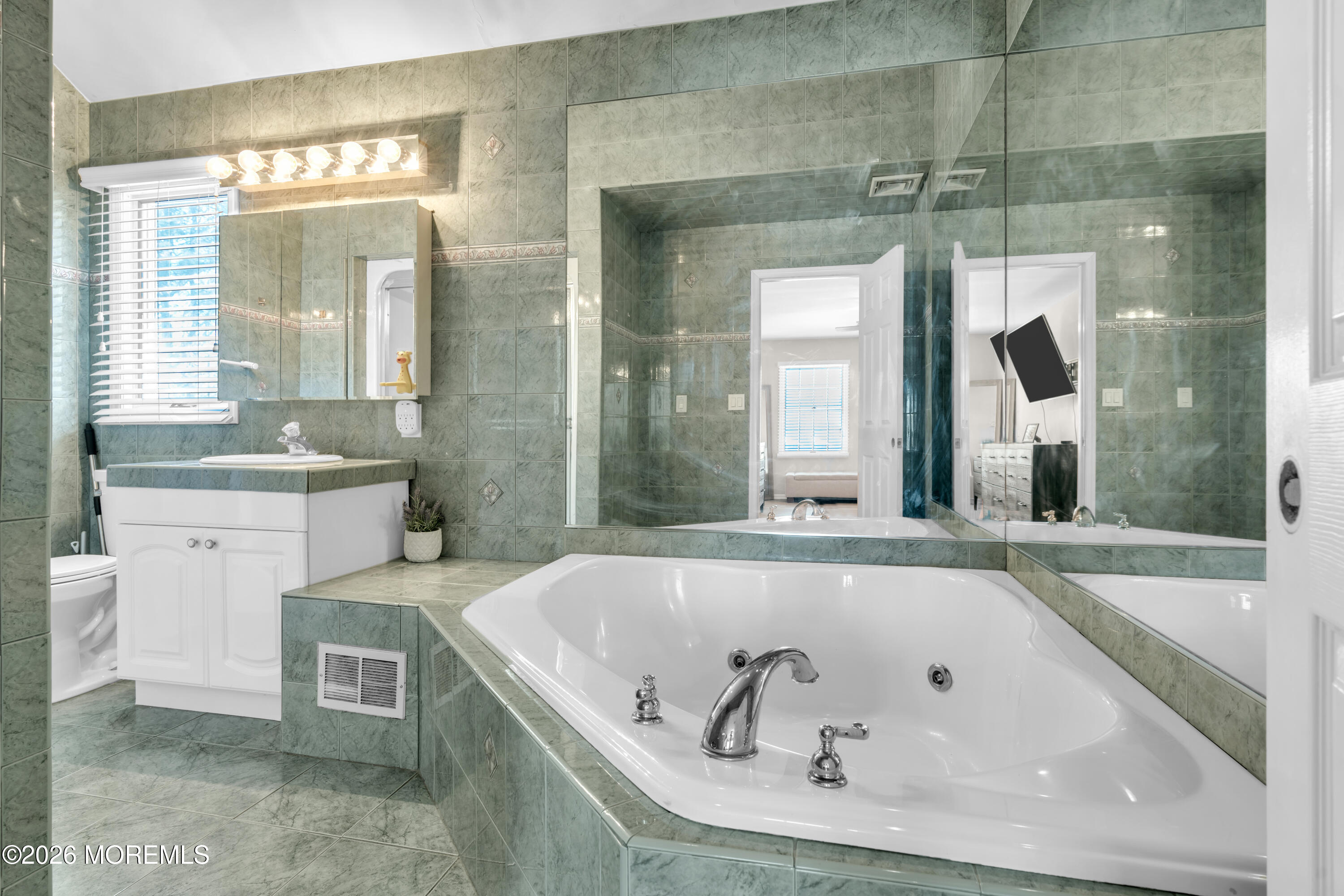 15 Lenape Trail Freehold, NJ 07728 - Photo 4 of 27 a bathroom with a tub a sink and a large mirror