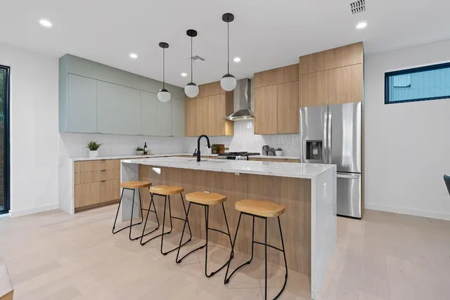 a kitchen with kitchen island granite countertop a sink a center island and stainless steel appliances