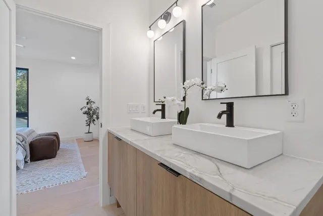 a bathroom with a double vanity sink toilet mirror and bathtub