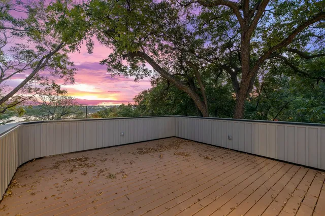 a view of balcony with wooden floor and fence