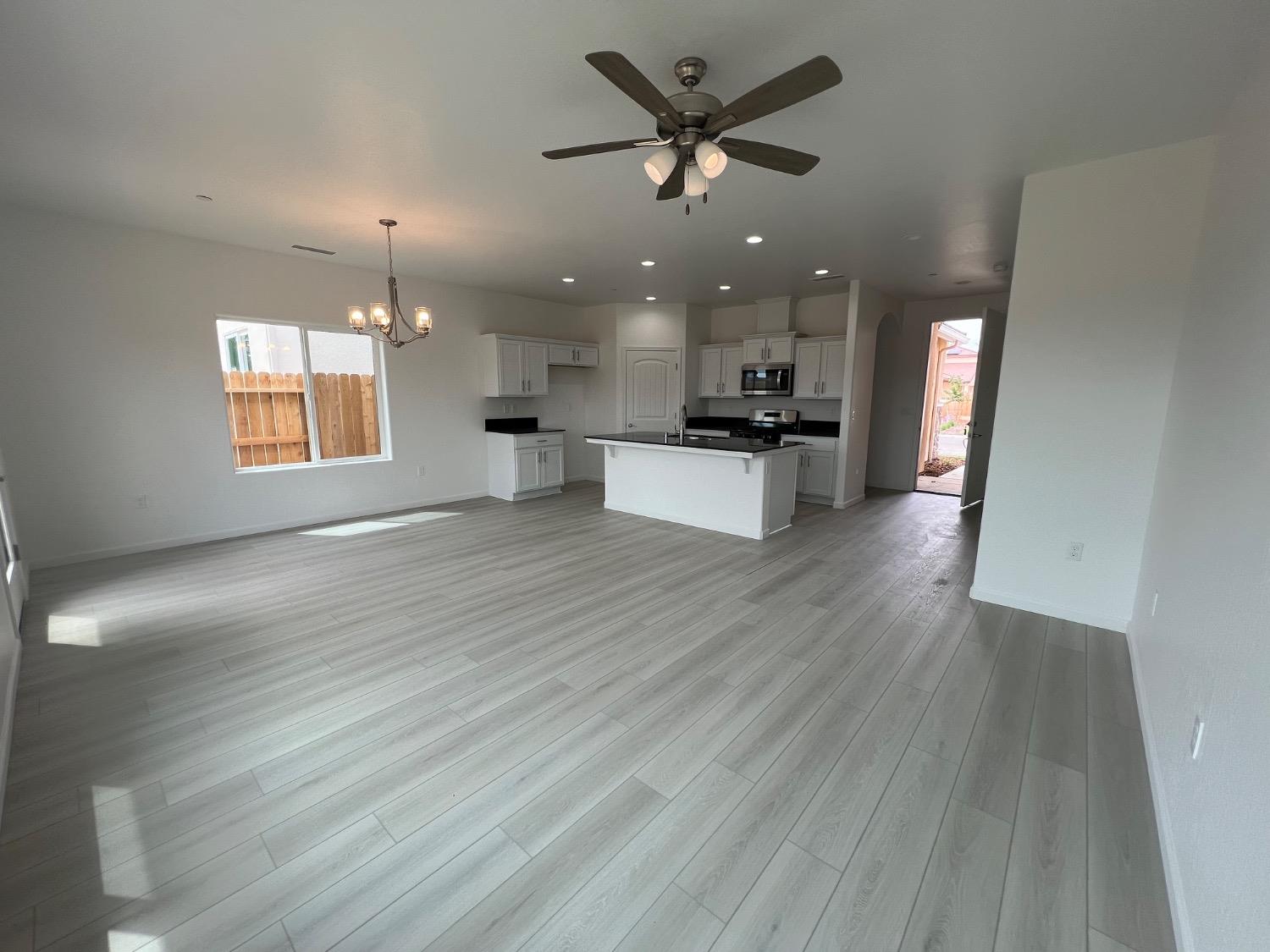 1502 Concord Way Dinuba, CA 93618 - Photo 6 of 12 an open kitchen with kitchen island wooden floors appliances and a fireplace