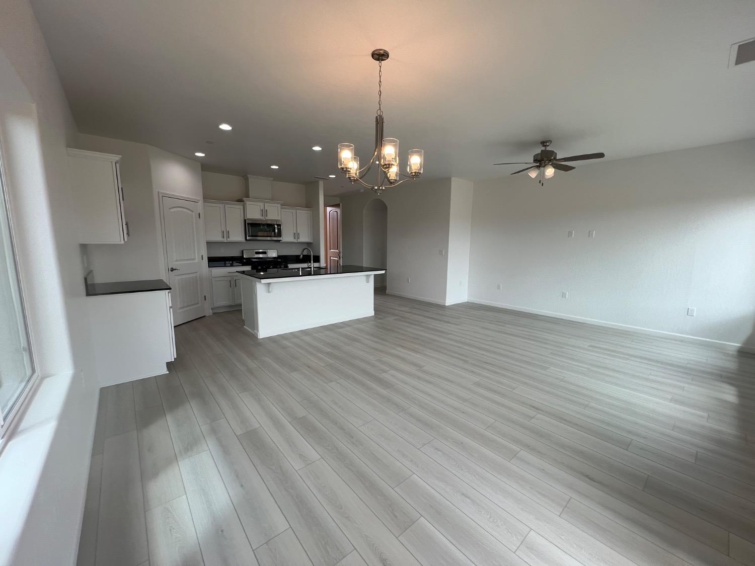 1502 Concord Way Dinuba, CA 93618 - Photo 7 of 12 a view of a kitchen with granite countertop stainless steel appliances sink and wooden floor