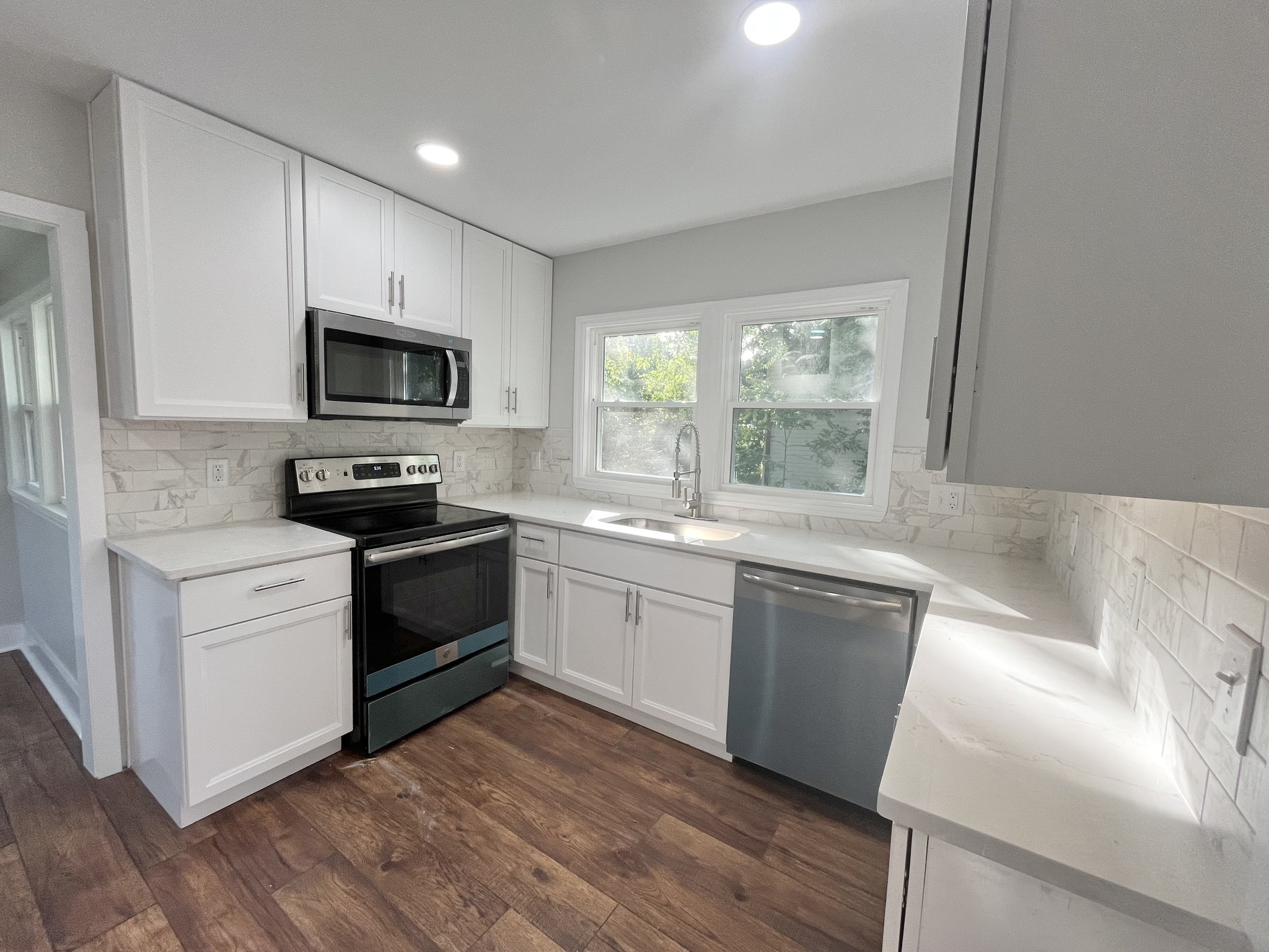 733 East Spring Street Cookeville, TN 38501 - Photo 5 of 23 a kitchen with a sink wooden floor and stainless steel appliances