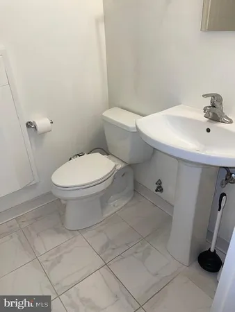 a white toilet sitting next to a bathroom sink